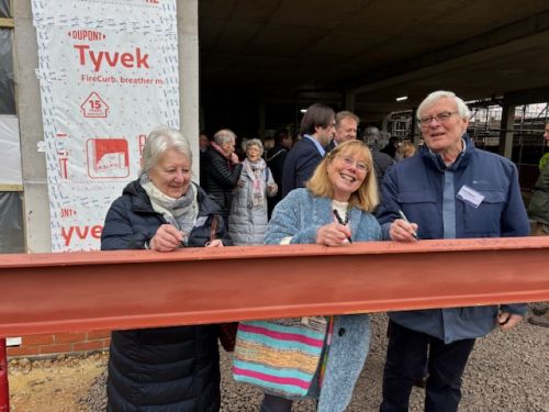 Members of the Committee sign the roof support beam for the new Phyllis Tuckwell Hospice